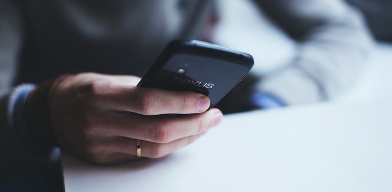 image of a man holding a black phone