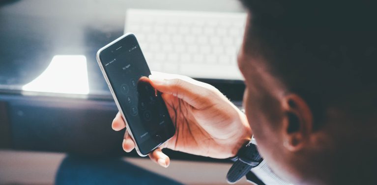 image of a man using a phone in an office space.