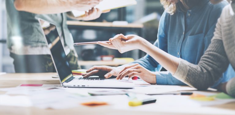 image of a 3 person meeting looking at a computer and making notes.