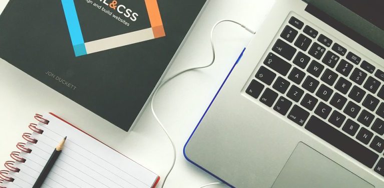 image of stationary and a laptop with headphones laid out neatly