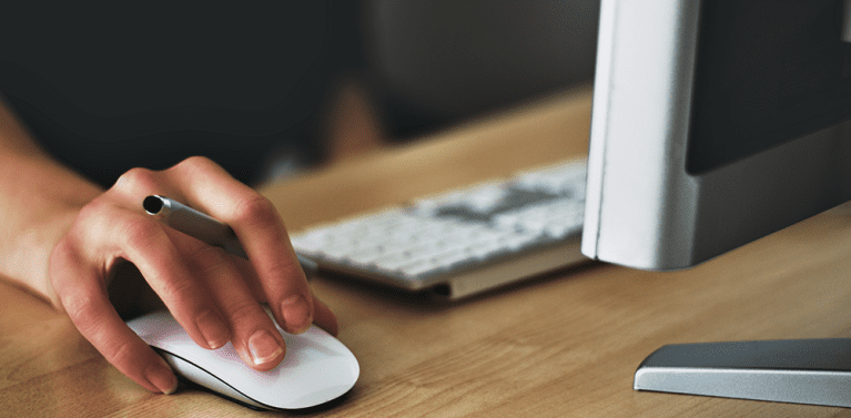 image of a persons hand using a mouse for their computer.