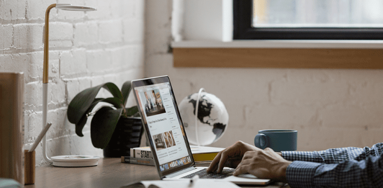 image of a mans hands using a computer in a nicely decorated office.