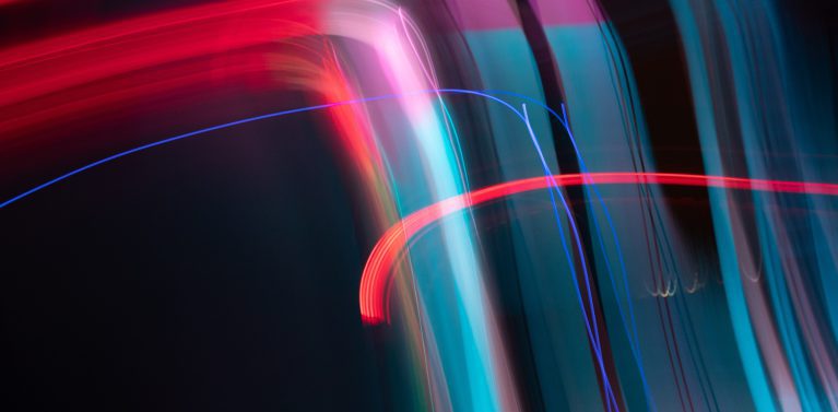 image of a black background with colourful light streaks across the image in blue, red and purple