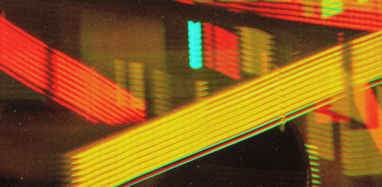 image of orange, yellow and blue building lights reflected on a window.