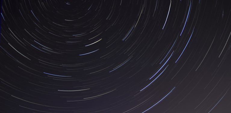 image of a starry night sky motion picture. stars swirl round to create a spiral.
