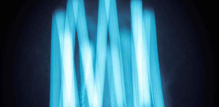 image with a blacked background, a circular zigzag pattern in blue light.