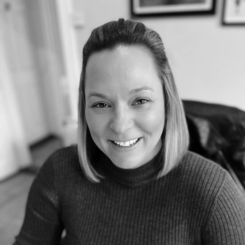 A black and white image of Natalie sitting at her desk